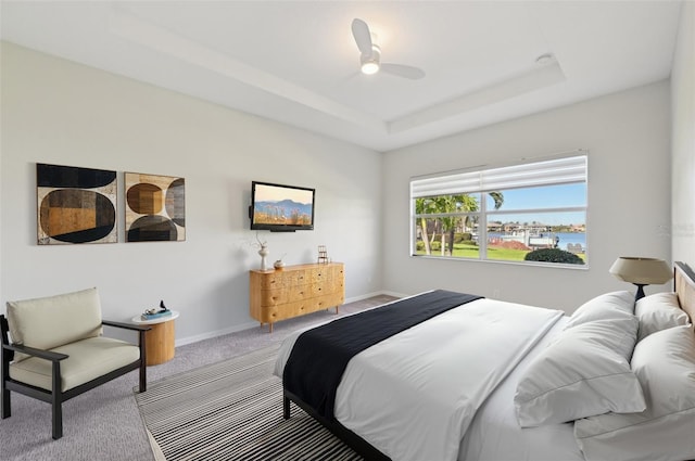 bedroom featuring carpet flooring, a raised ceiling, and ceiling fan