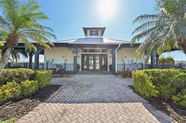 view of front of home with covered porch and french doors