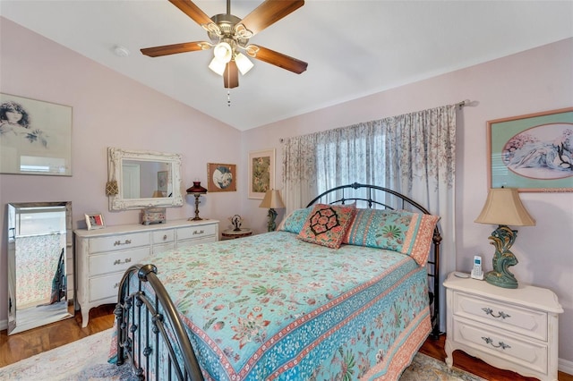 bedroom featuring ceiling fan, dark hardwood / wood-style flooring, and vaulted ceiling