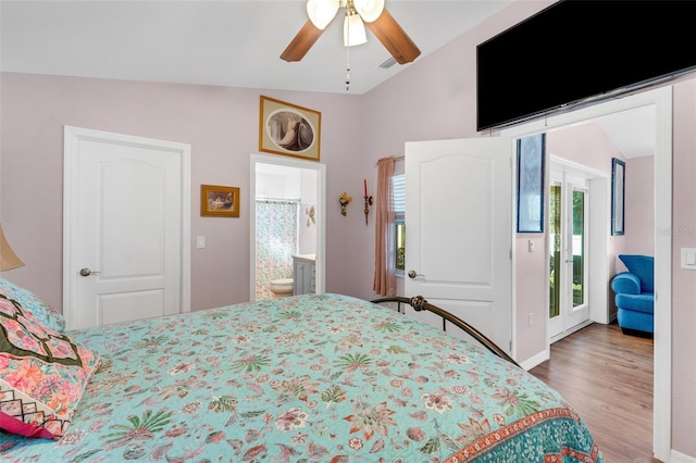 bedroom featuring hardwood / wood-style floors, lofted ceiling, ensuite bath, ceiling fan, and access to exterior