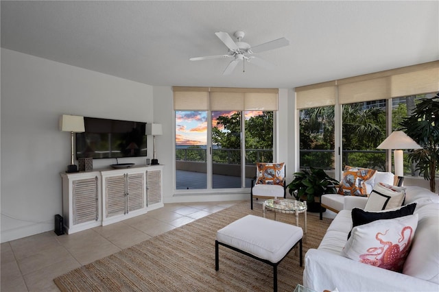 tiled living room featuring ceiling fan and expansive windows