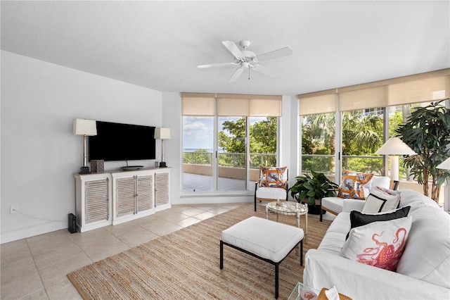 living room with light tile patterned floors, a wall of windows, and ceiling fan