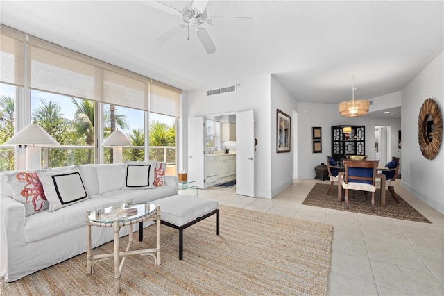 living room with a baseboard radiator, ceiling fan, and light tile patterned flooring