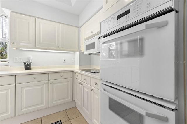 kitchen featuring white cabinets, white appliances, and light tile patterned floors