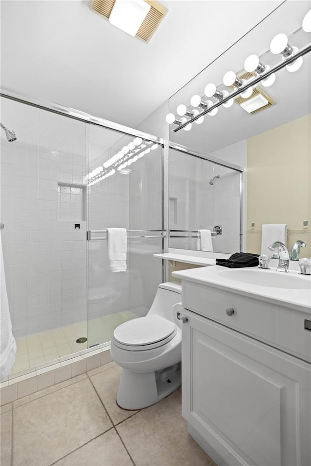 bathroom with tile patterned flooring, vanity, toilet, and a shower with shower door