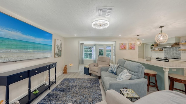 living room featuring light hardwood / wood-style floors and a textured ceiling