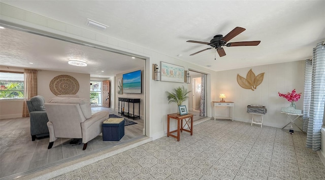 living room featuring a wealth of natural light and ceiling fan