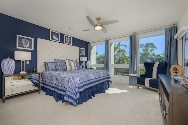 carpeted bedroom with ceiling fan and a textured ceiling