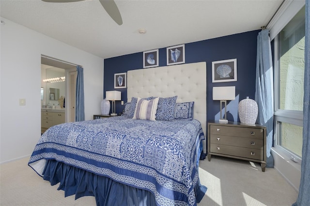 carpeted bedroom with ceiling fan, a textured ceiling, and connected bathroom