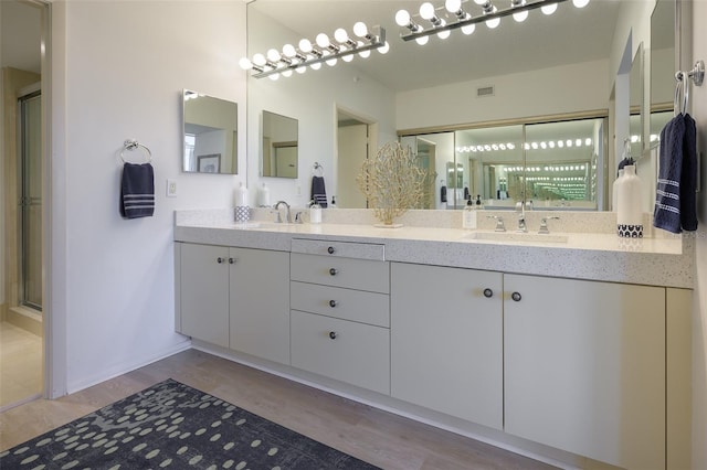 bathroom featuring wood-type flooring, vanity, and walk in shower