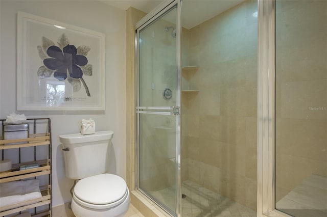 bathroom featuring toilet and a shower with shower door