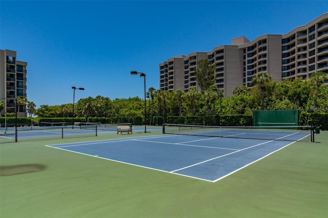 view of tennis court featuring basketball hoop