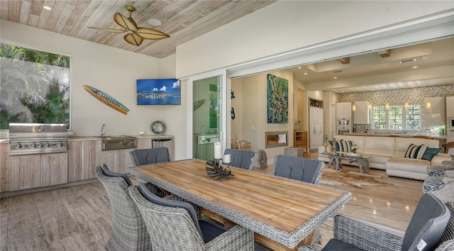 dining room with light hardwood / wood-style flooring, ceiling fan, wooden ceiling, and sink