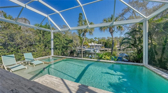 view of pool with an in ground hot tub and a lanai