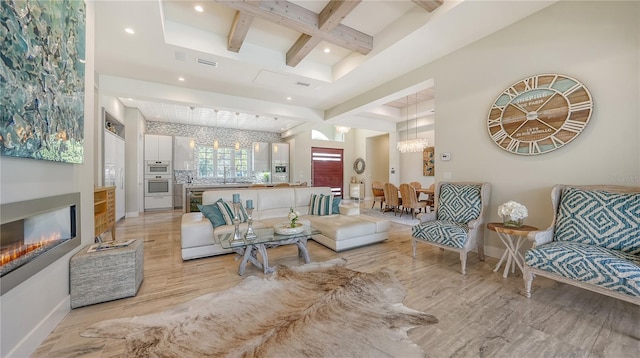 living room with beam ceiling, light wood-type flooring, coffered ceiling, and sink