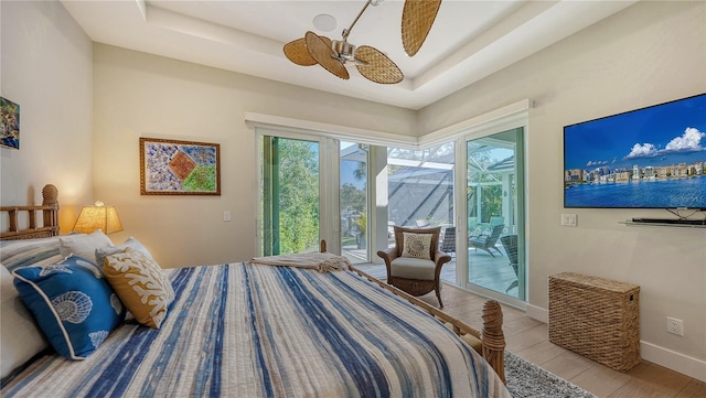 bedroom with light hardwood / wood-style floors, access to outside, and a tray ceiling