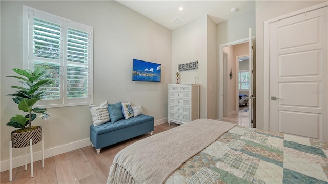 bedroom with multiple windows and light hardwood / wood-style floors