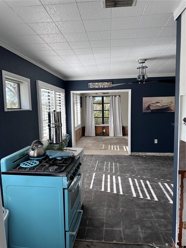 interior space with gas range, a wealth of natural light, and ornamental molding