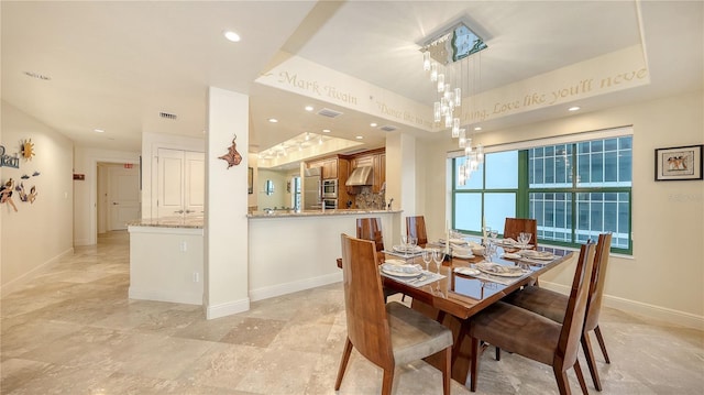 dining room with a raised ceiling