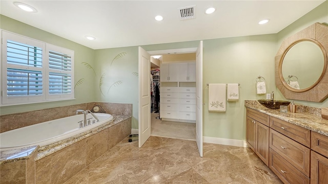 bathroom featuring vanity and tiled bath