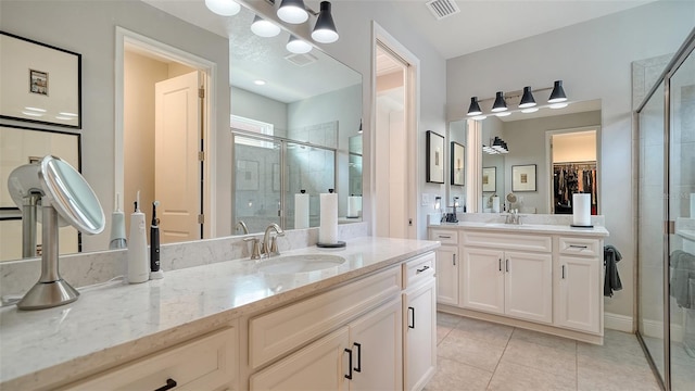 bathroom featuring tile patterned flooring, vanity, and a shower with shower door