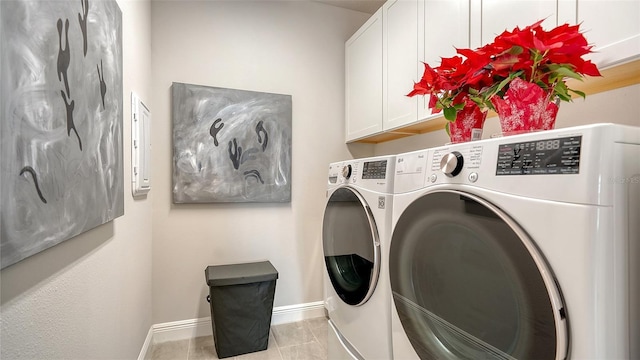 laundry room featuring cabinets, light tile patterned floors, and washing machine and dryer