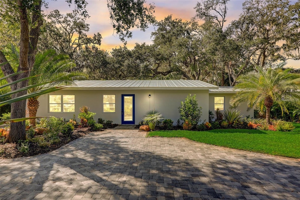 ranch-style home with a lawn