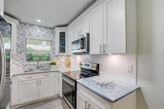 730 40th St, Sarasota, FL 34234 - kitchen featuring stainless steel appliances, tasteful backsplash, white cabinetry, glass insert cabinets, and recessed lighting