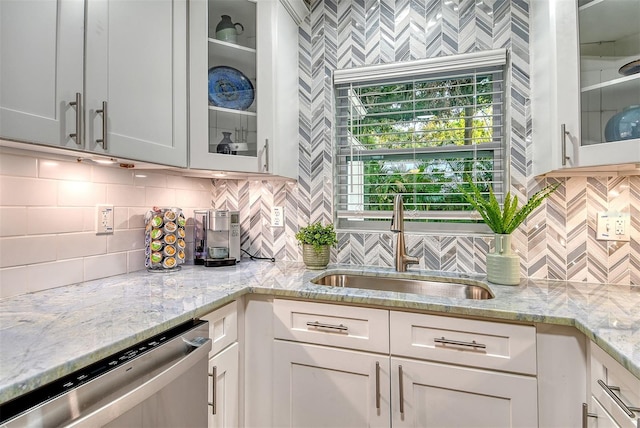 730 40th St, Sarasota, FL 34234 - kitchen featuring stainless steel dishwasher, backsplash, white cabinets, and light stone counters