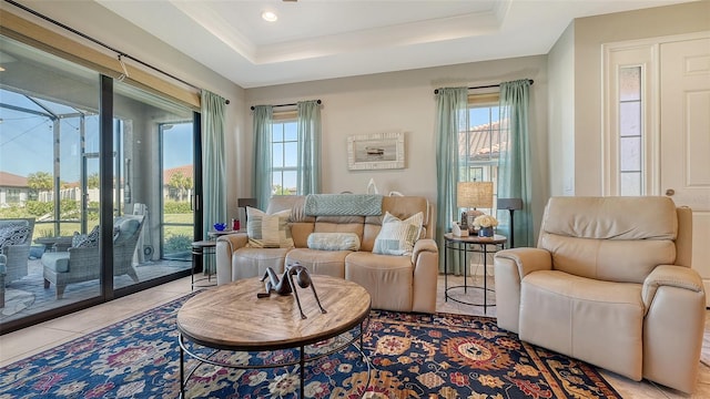 living area with a raised ceiling, a wealth of natural light, and light tile patterned flooring