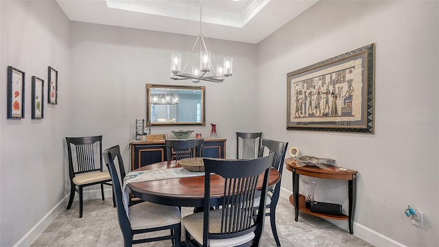 dining area featuring a notable chandelier, crown molding, and a tray ceiling