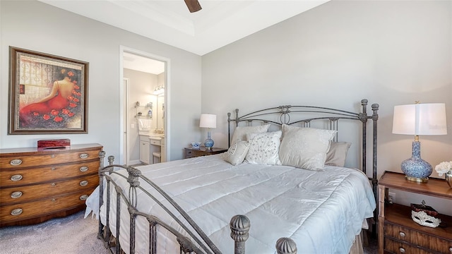 carpeted bedroom with ensuite bath and ceiling fan