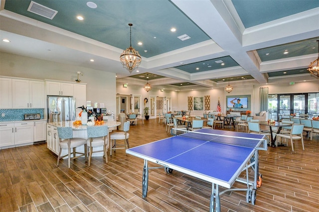 game room with a notable chandelier, beam ceiling, crown molding, and coffered ceiling