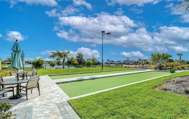 view of home's community with a water view and a yard