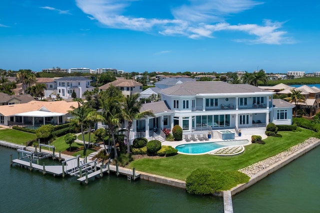 rear view of house with a balcony, a water view, and a patio