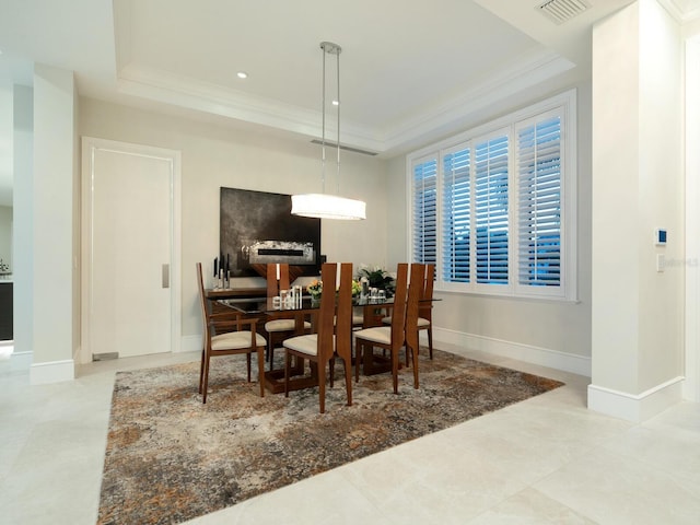 dining room with a tray ceiling and ornamental molding