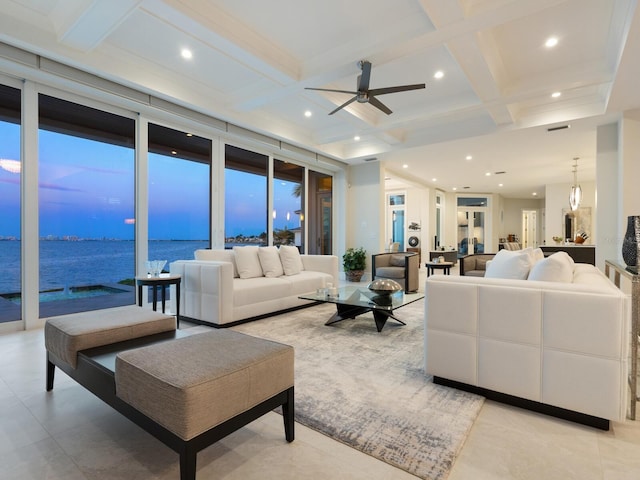 living room featuring floor to ceiling windows, ceiling fan, coffered ceiling, beamed ceiling, and a water view