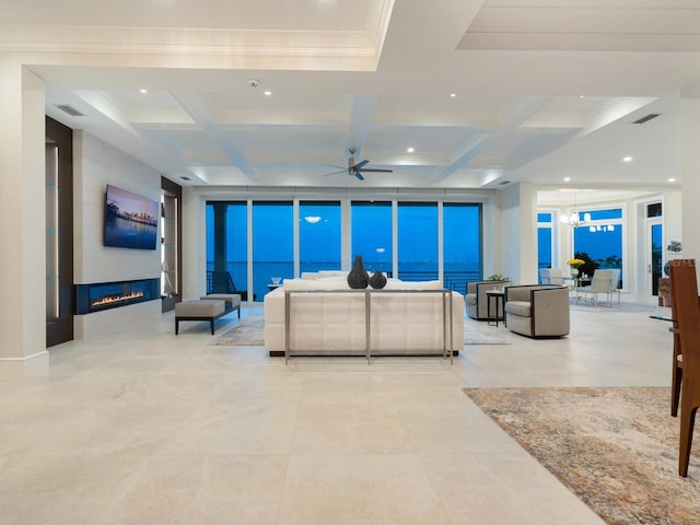 living room with a large fireplace, coffered ceiling, beamed ceiling, crown molding, and ceiling fan with notable chandelier