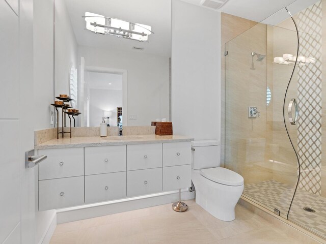 bathroom featuring tile patterned flooring, vanity, toilet, and an enclosed shower