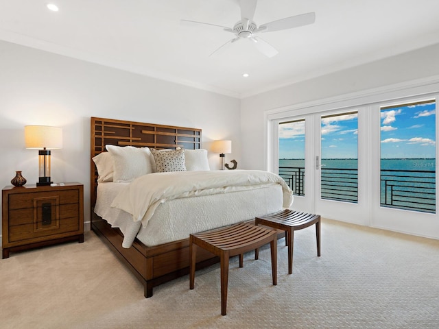 carpeted bedroom featuring access to exterior, a water view, ceiling fan, and ornamental molding