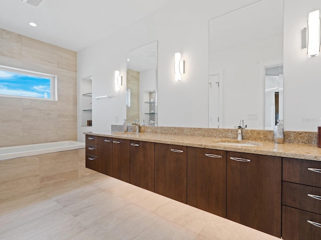 bathroom featuring vanity and tiled tub