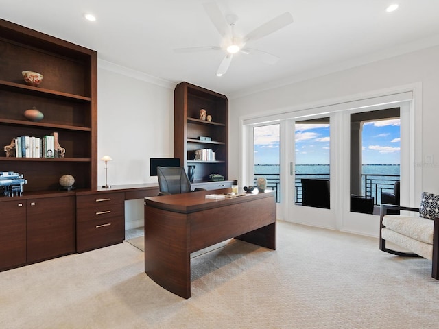 carpeted home office featuring a water view, ceiling fan, and crown molding