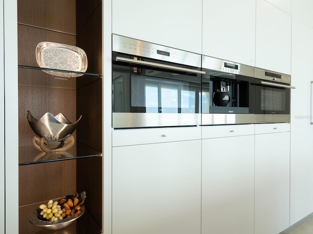 kitchen with white cabinets, wall oven, and oven