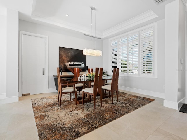 dining room with a raised ceiling, crown molding, and light tile patterned floors