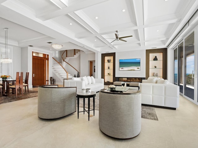 living room featuring coffered ceiling, built in shelves, ceiling fan, a healthy amount of sunlight, and beam ceiling