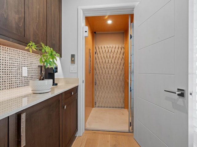 interior space with decorative backsplash, vanity, and hardwood / wood-style flooring