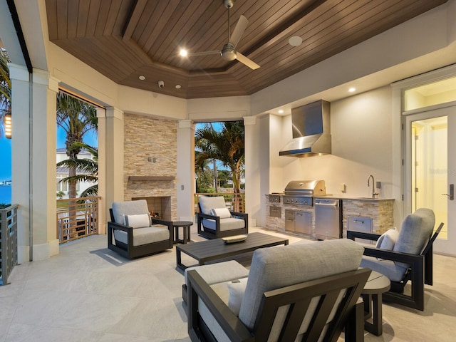 interior space with ceiling fan, sink, an outdoor kitchen, an outdoor living space with a fireplace, and grilling area