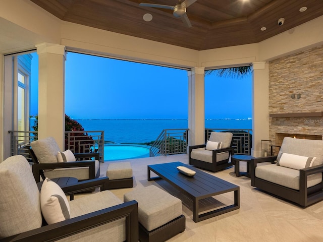 view of patio / terrace featuring ceiling fan, a swimming pool, a water view, and an outdoor hangout area