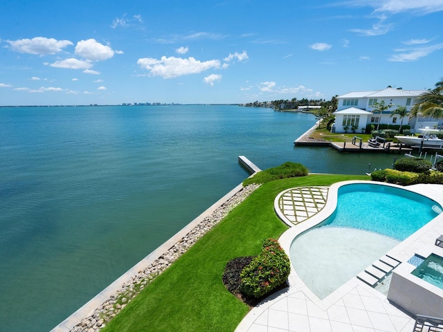 view of swimming pool with a lawn and a water view