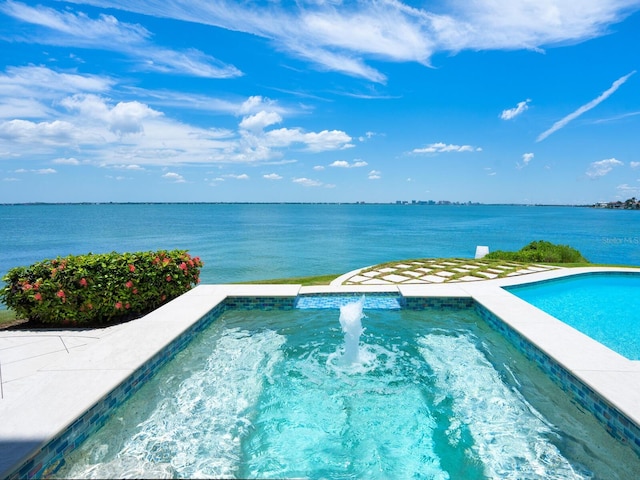 view of swimming pool with a jacuzzi and a water view